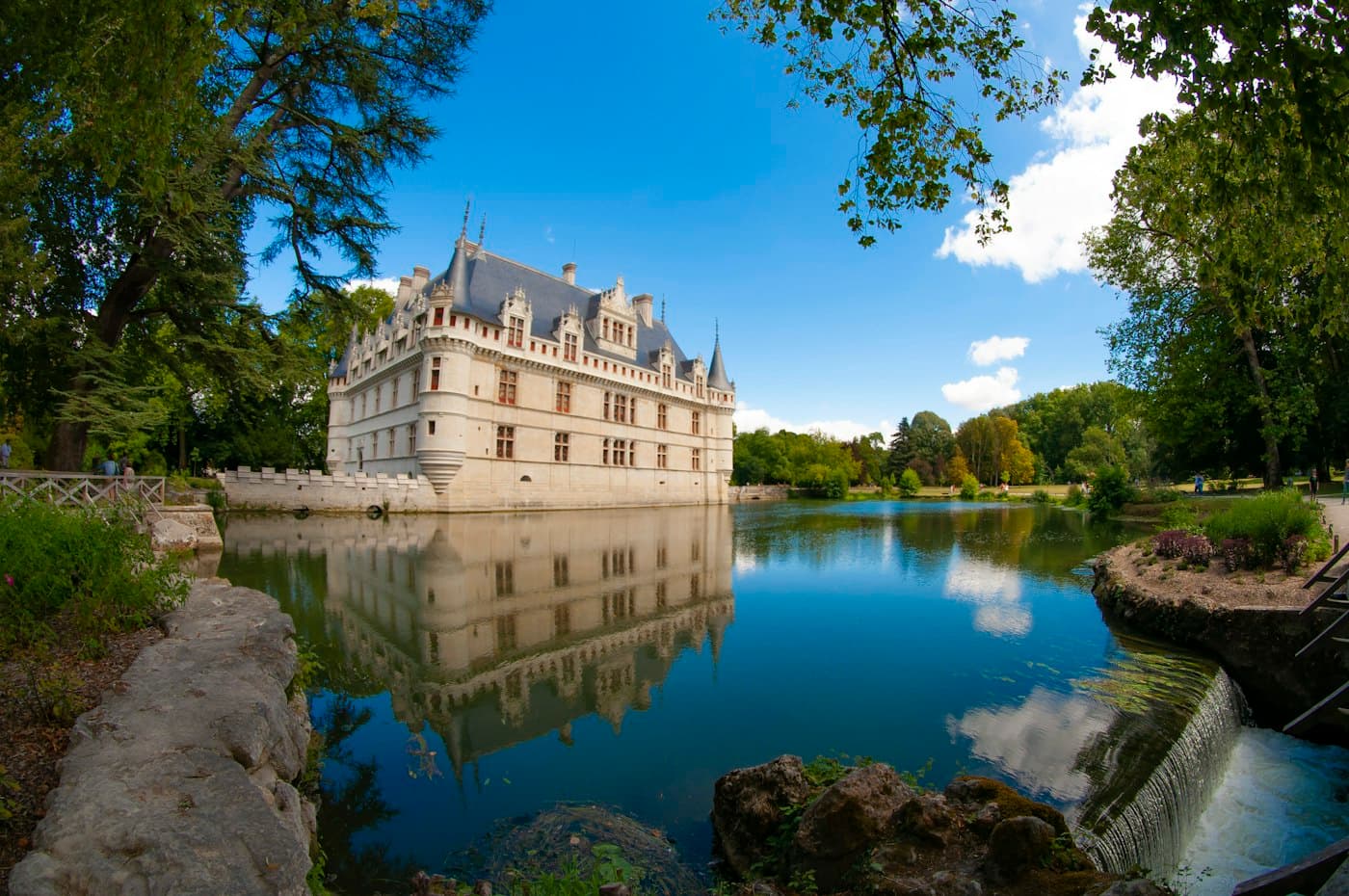 The Château d’Azay-le-Rideau reflected in its lake among tall trees