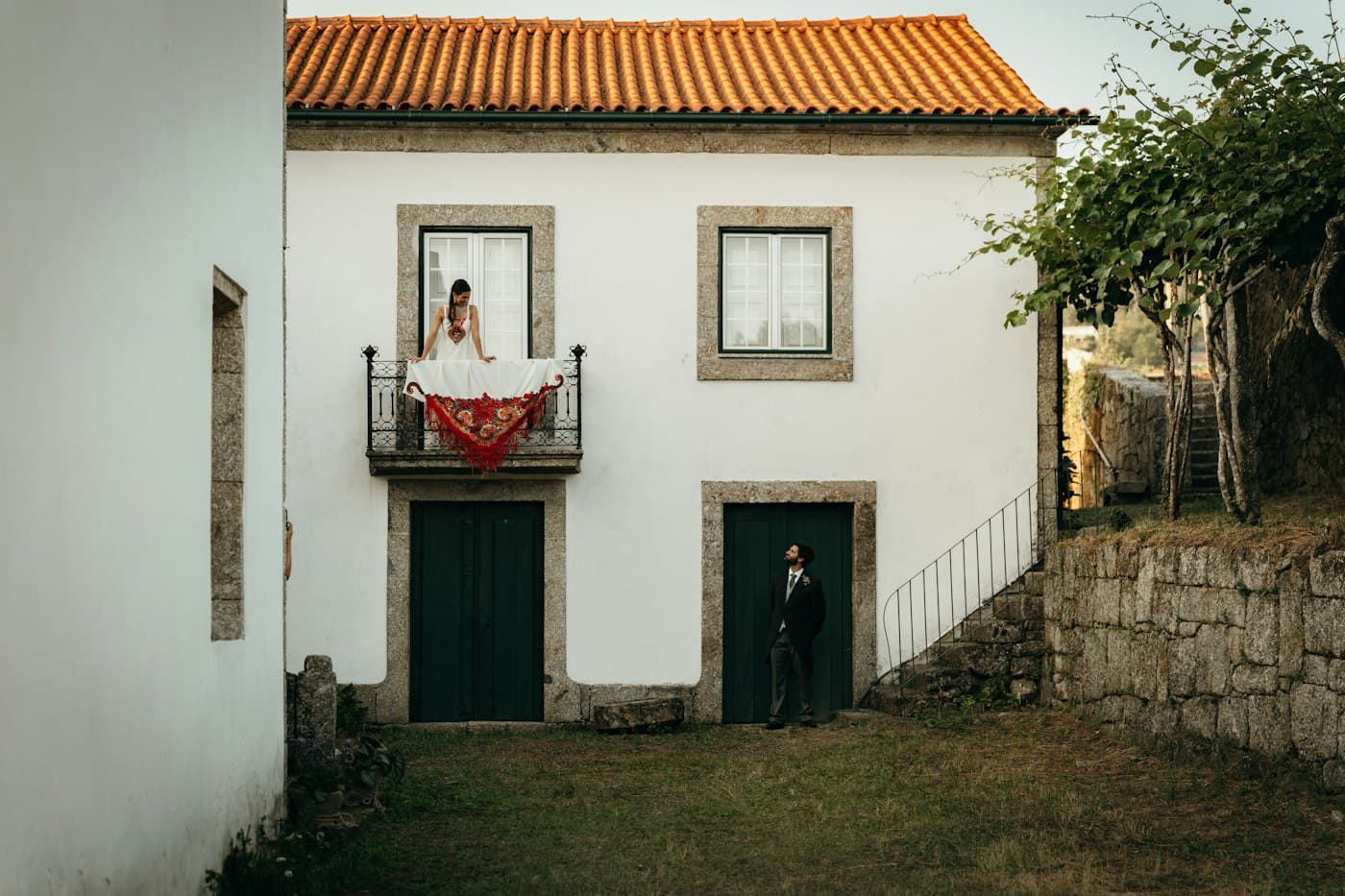 A bride on the balcony of a white Portuguese house
