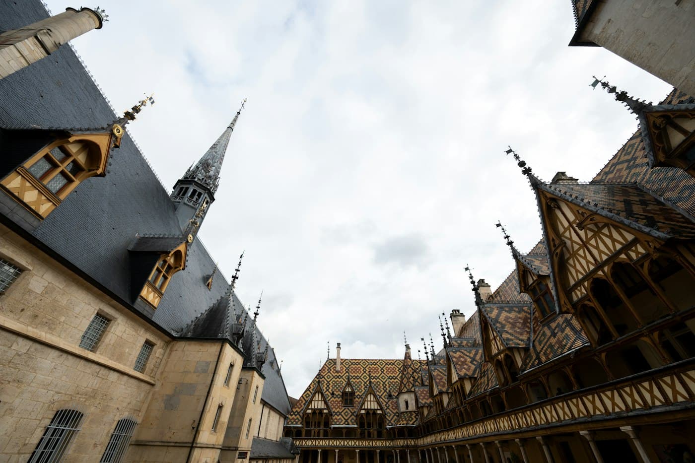 The glazed tile roofs and spires of the Hospices de Beaune courtyard