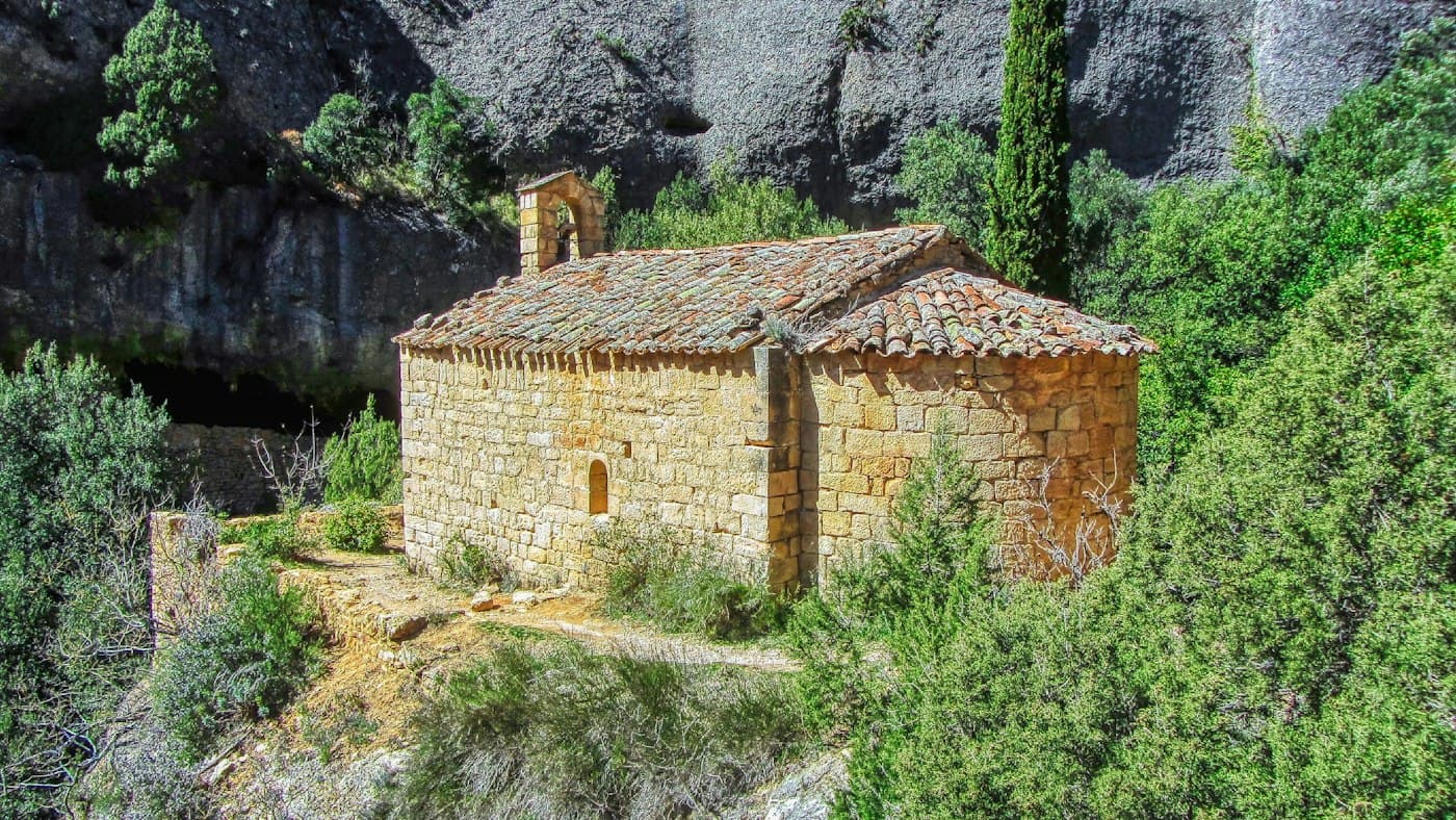 A small stone chapel among rocks and green trees in Catalonia
