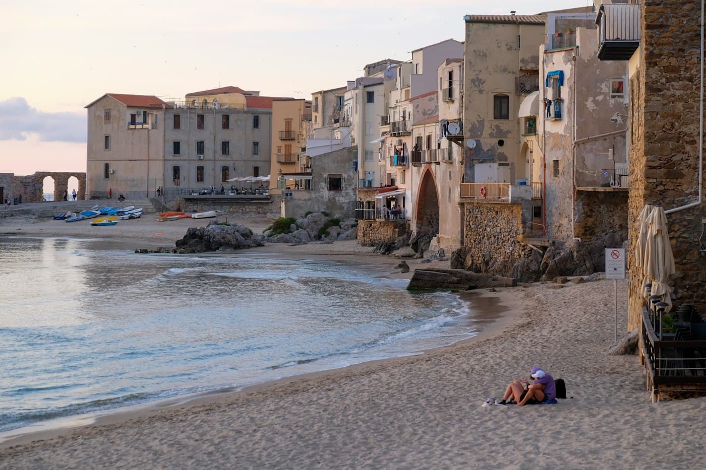 The old town of Cefalù above its beach at dusk