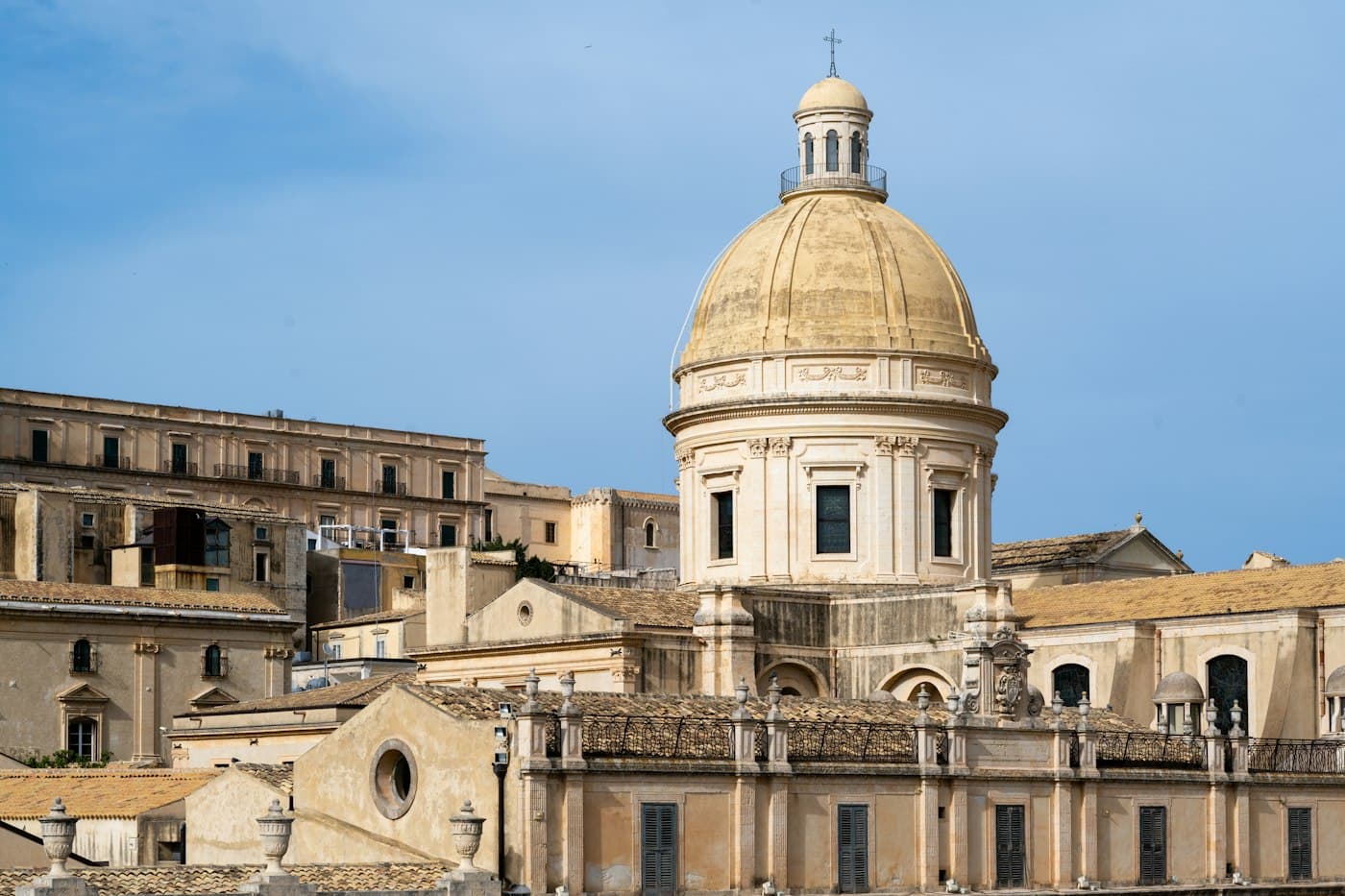 La cupola della cattedrale che si alza sopra gli edifici in pietra color miele di Noto