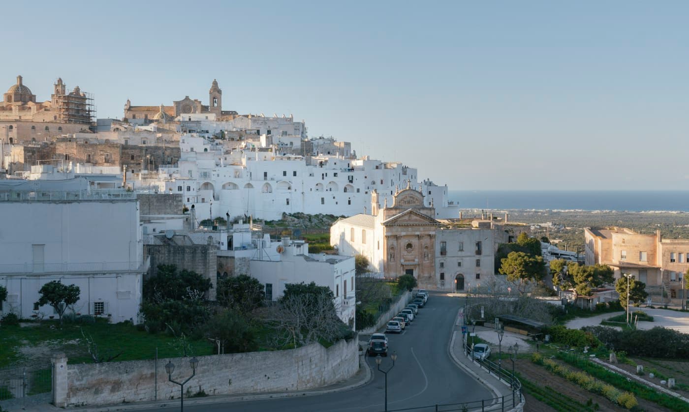 Ostuni’s white old town on its hill above a baroque church, the sea in the distance