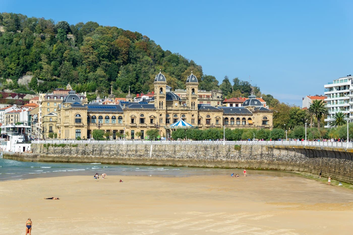 El ayuntamiento de San Sebastián, el antiguo casino, tras la playa de La Concha con la marea baja