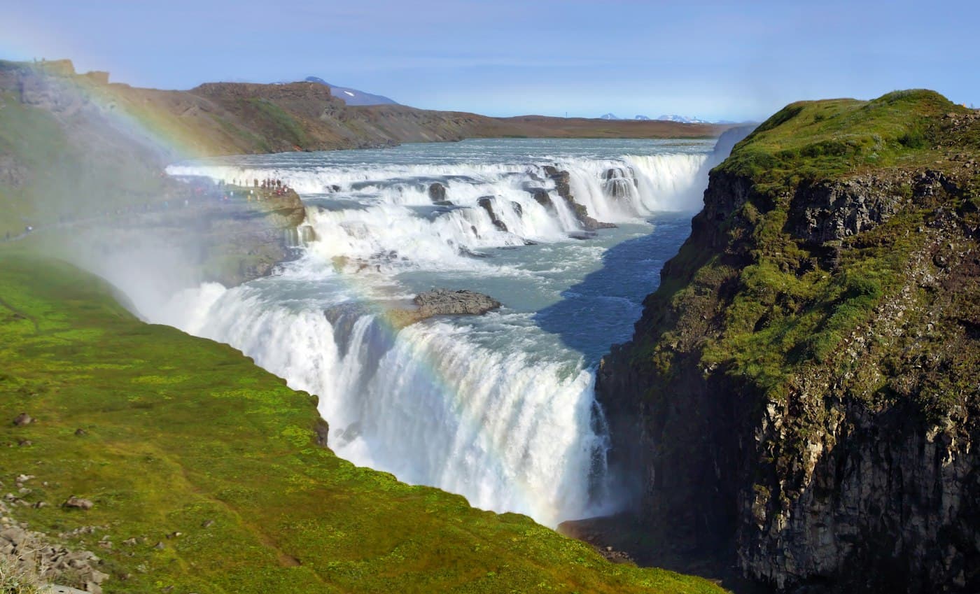 Der Gullfoss stürzt in zwei Stufen in seine Schlucht, ein Regenbogen in der Gischt