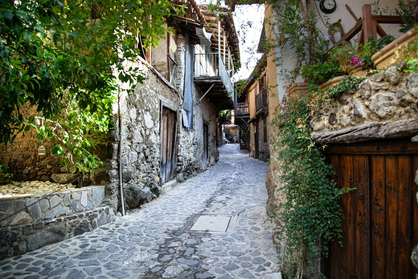 A cobbled lane in the old quarter of Kakopetria between stone houses with wooden balconies, vines and flowers