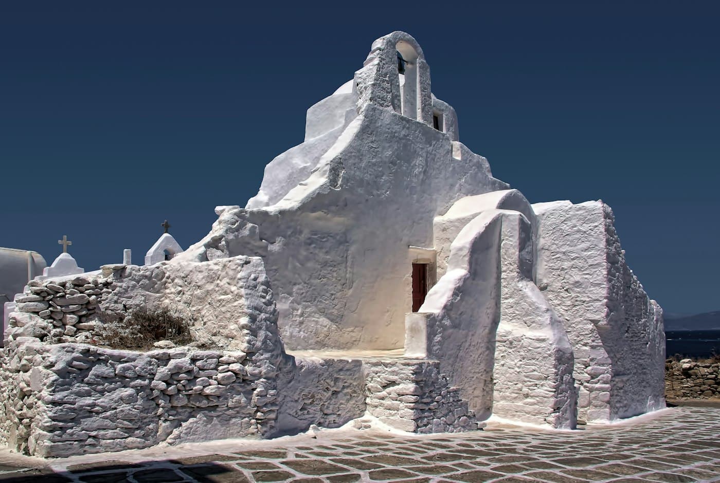 Die weiß gekalkte Kirche Panagia Paraportiani im Hauptort von Mykonos unter tiefblauem Himmel