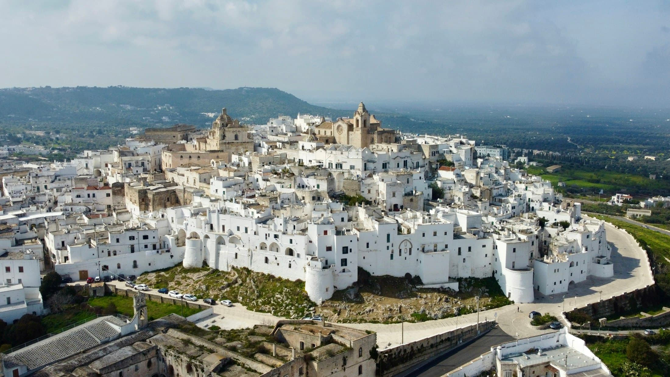 A cidade branca de Ostuni vista do ar, com a planície atrás