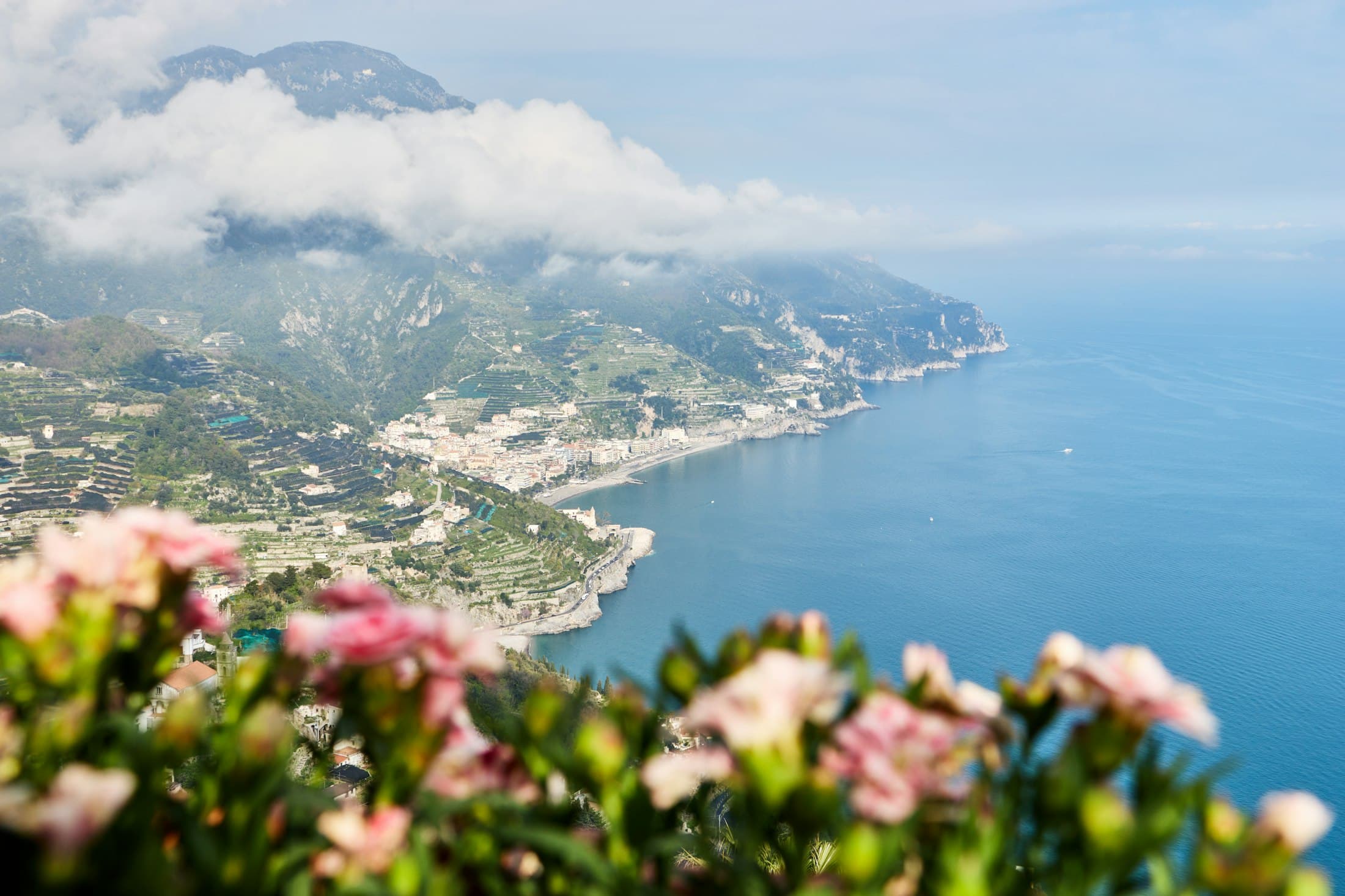 A Costa Amalfitana vista de um jardim em Ravello, com flores à frente