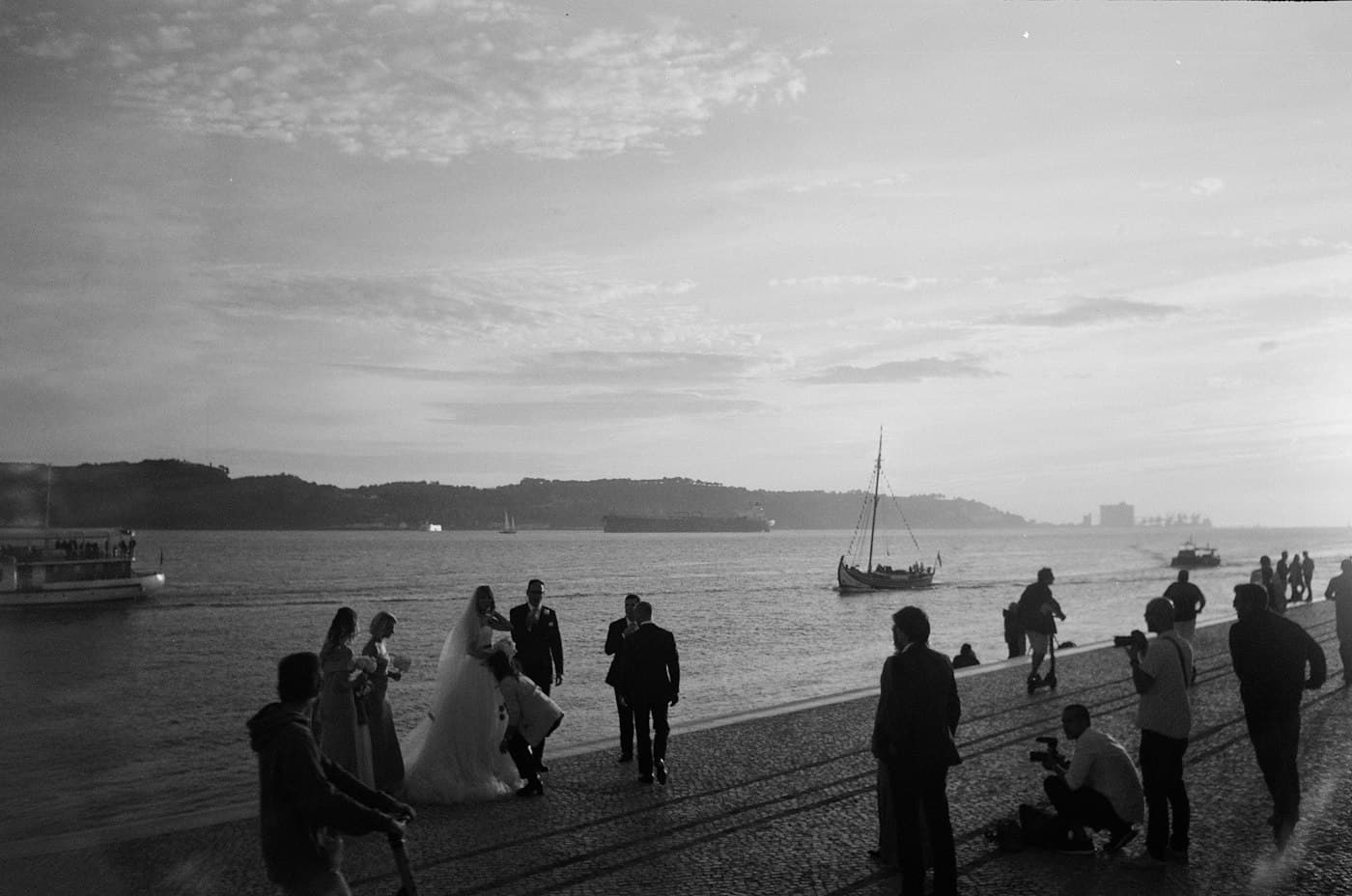 Wedding guests on a riverside in black and white