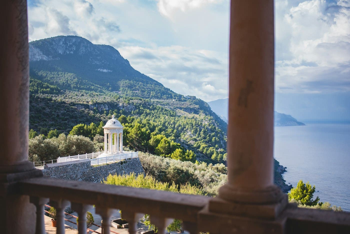 A white gazebo and the mountains above the sea, seen from a terrace in Mallorca
