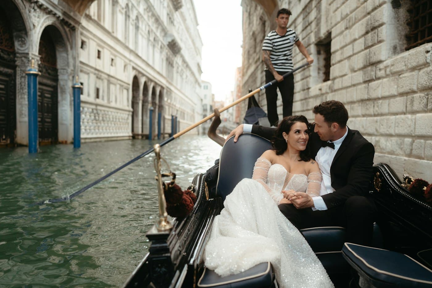 A bride and groom in a gondola on a Venetian canal