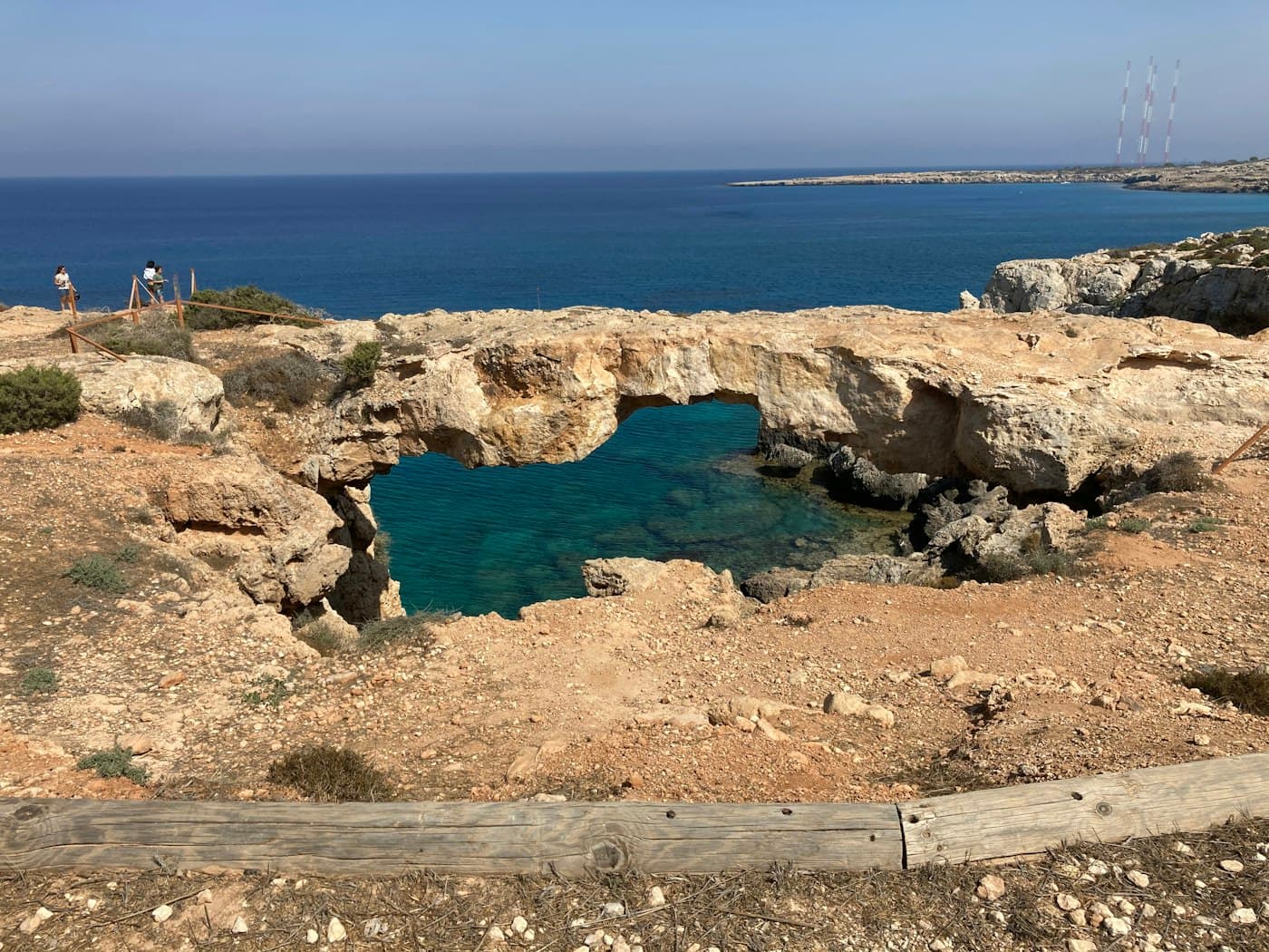 The natural rock arch of Kamara tou Koraka at Cape Greco, with clear blue water showing through it and the open sea beyond
