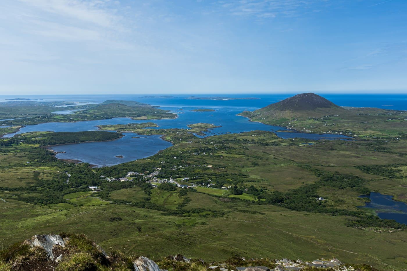 Connemara vom Gipfel des Diamond Hill: Moor und Wald, ein Dorf, Meeresarme und Inseln und ein kegelförmiger Berg am Atlantik