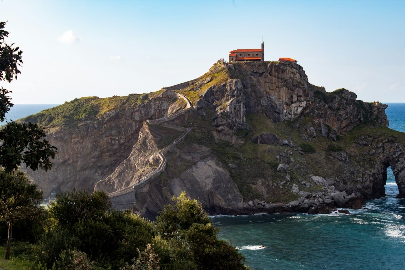 A hermitage on a rocky islet reached by a stone path, on the Basque coast