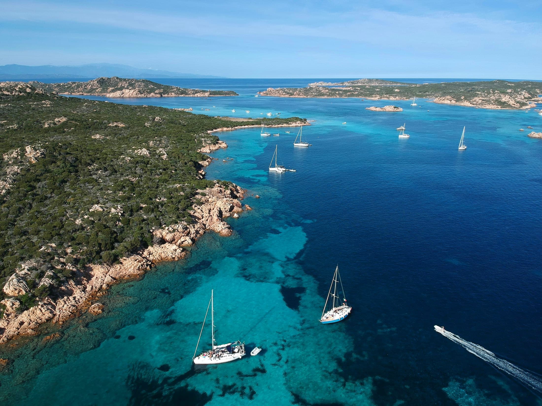 Segelboote vor Anker im klaren Wasser zwischen den Granitinseln von La Maddalena