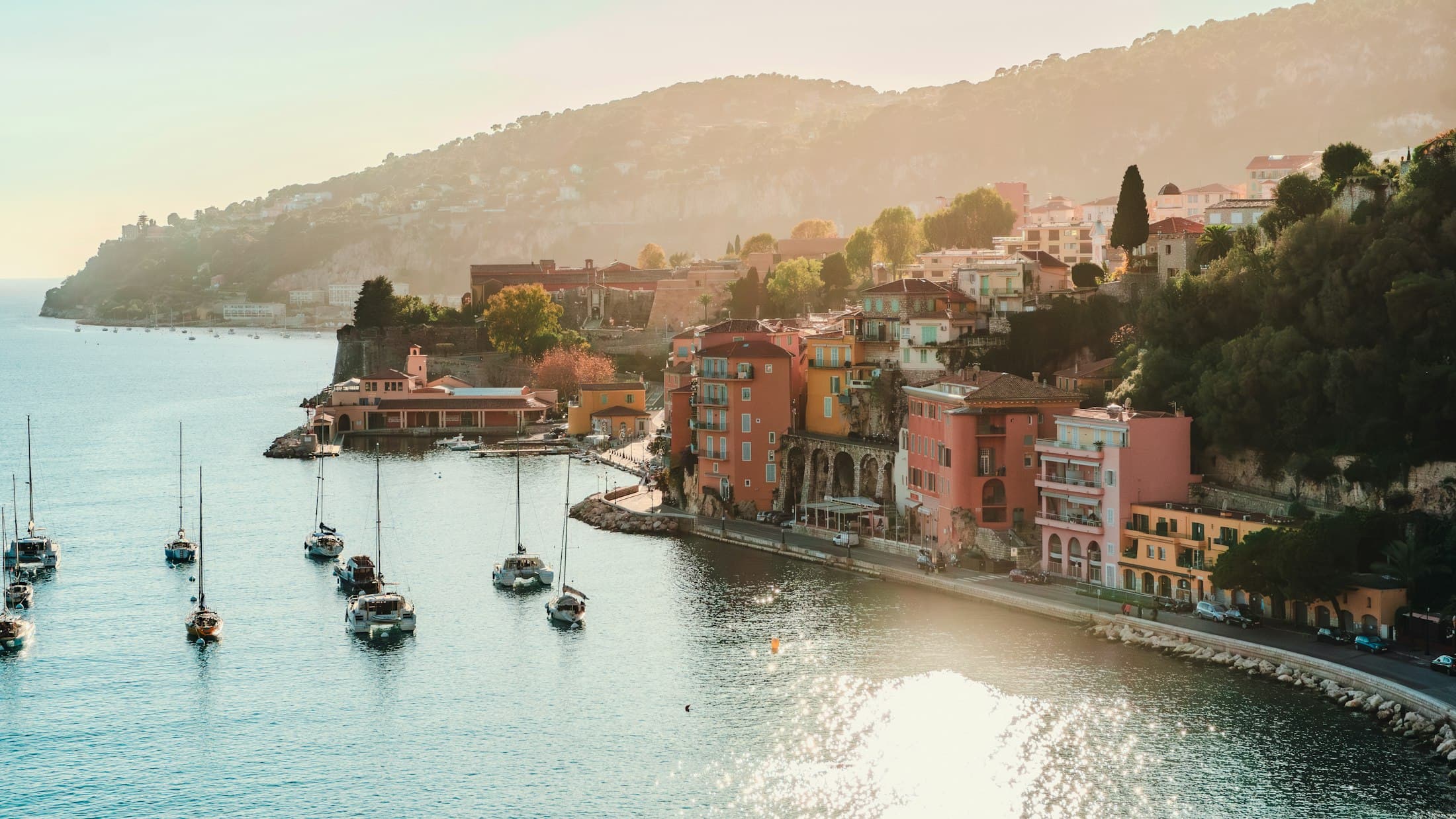 Sailing boats and pastel houses in the bay of Villefranche-sur-Mer in late-afternoon light